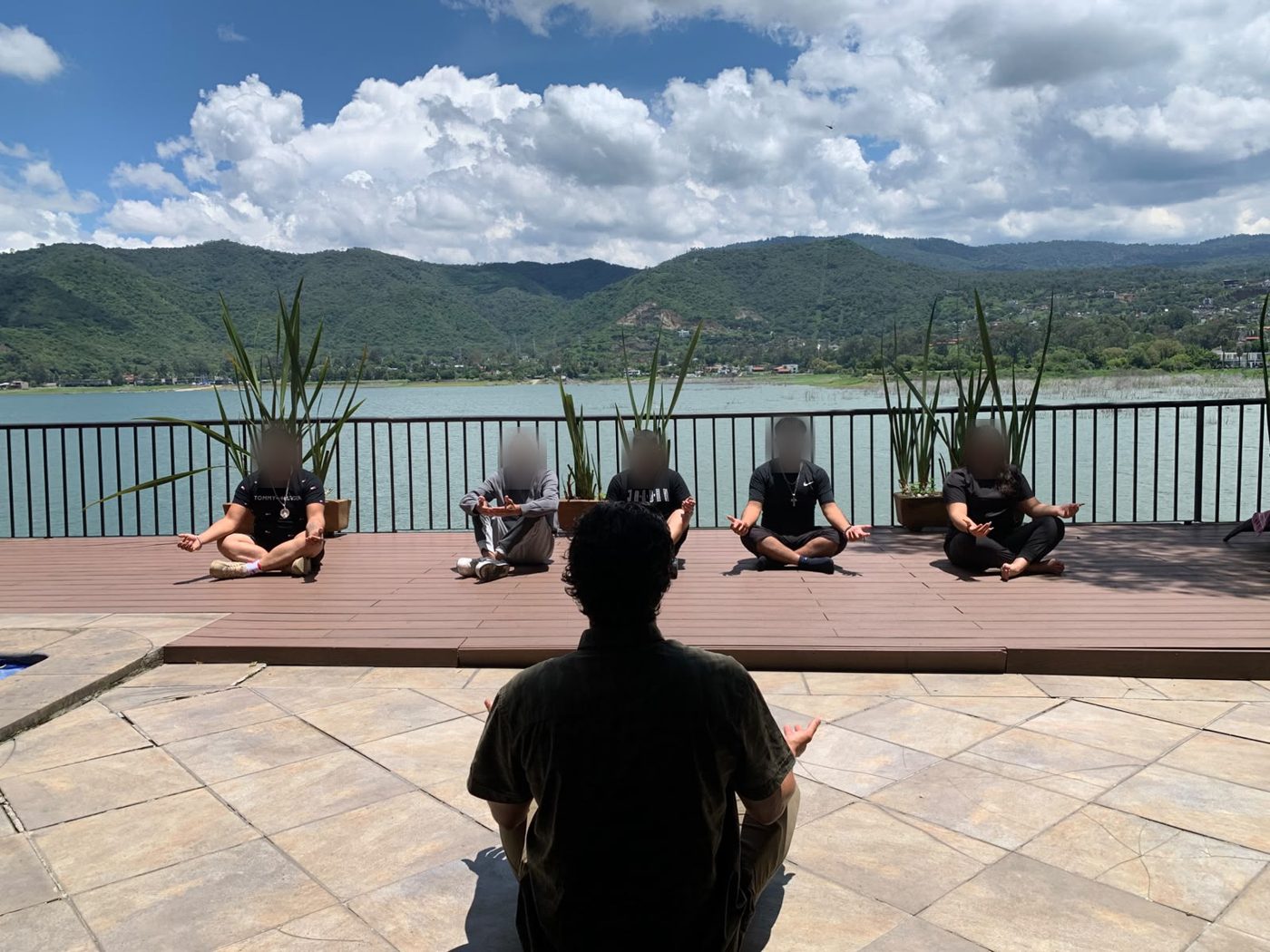 Sesión grupal de meditación al aire libre frente al lago